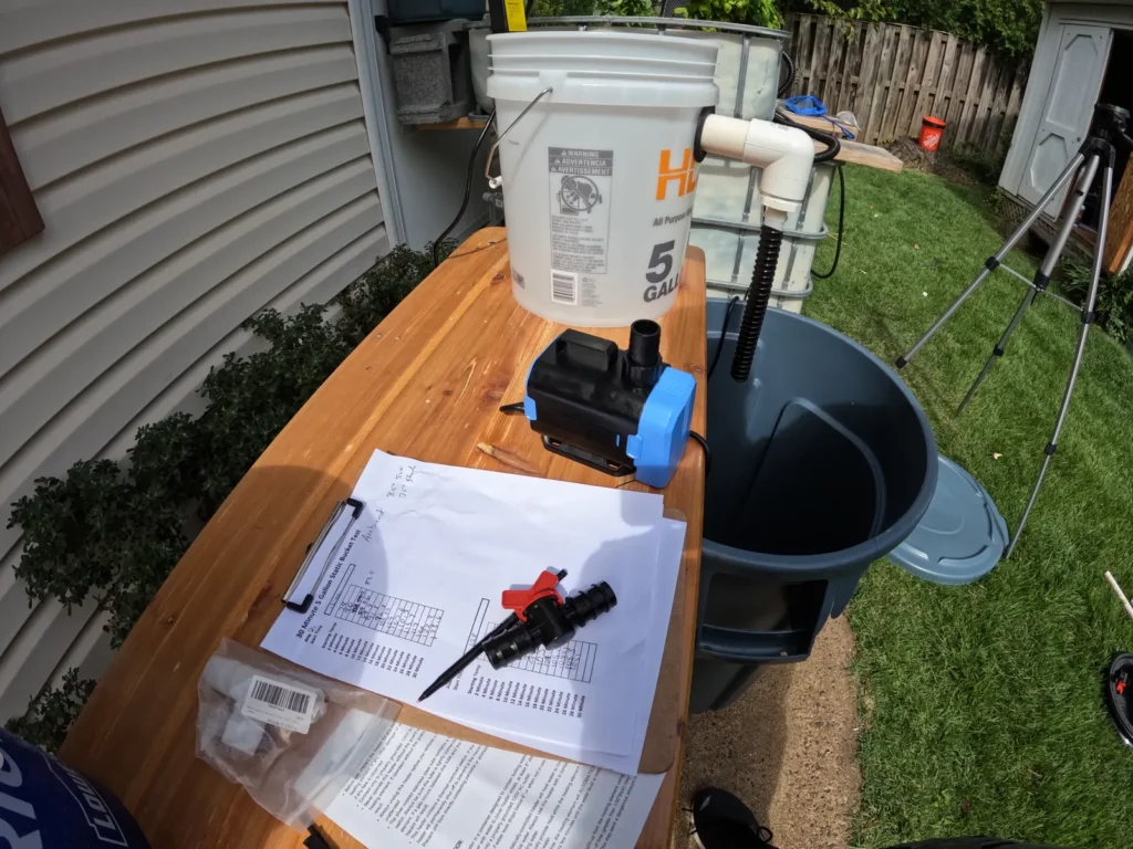 Aquaponics water-heater test setup with bucket, fittings, tools, and plans