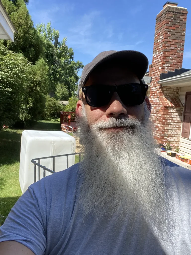 Aquaponics411 founder standing outside beside the backyard project area