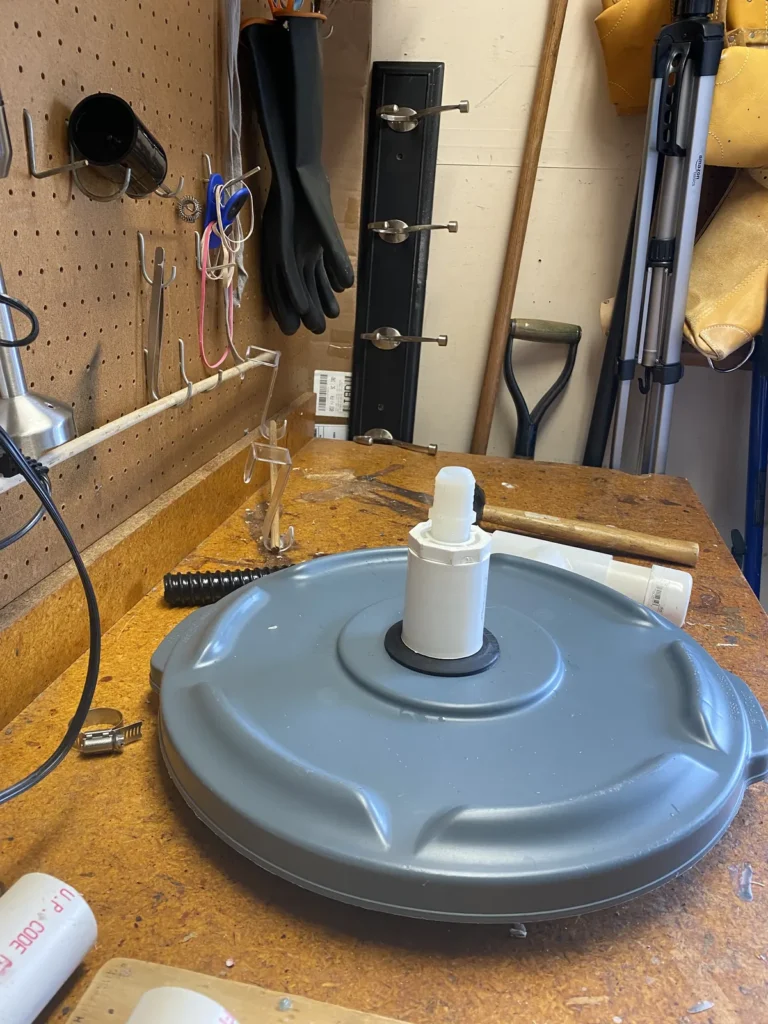 Homemade aquaponics filter container and standpipe assembly on a workbench
