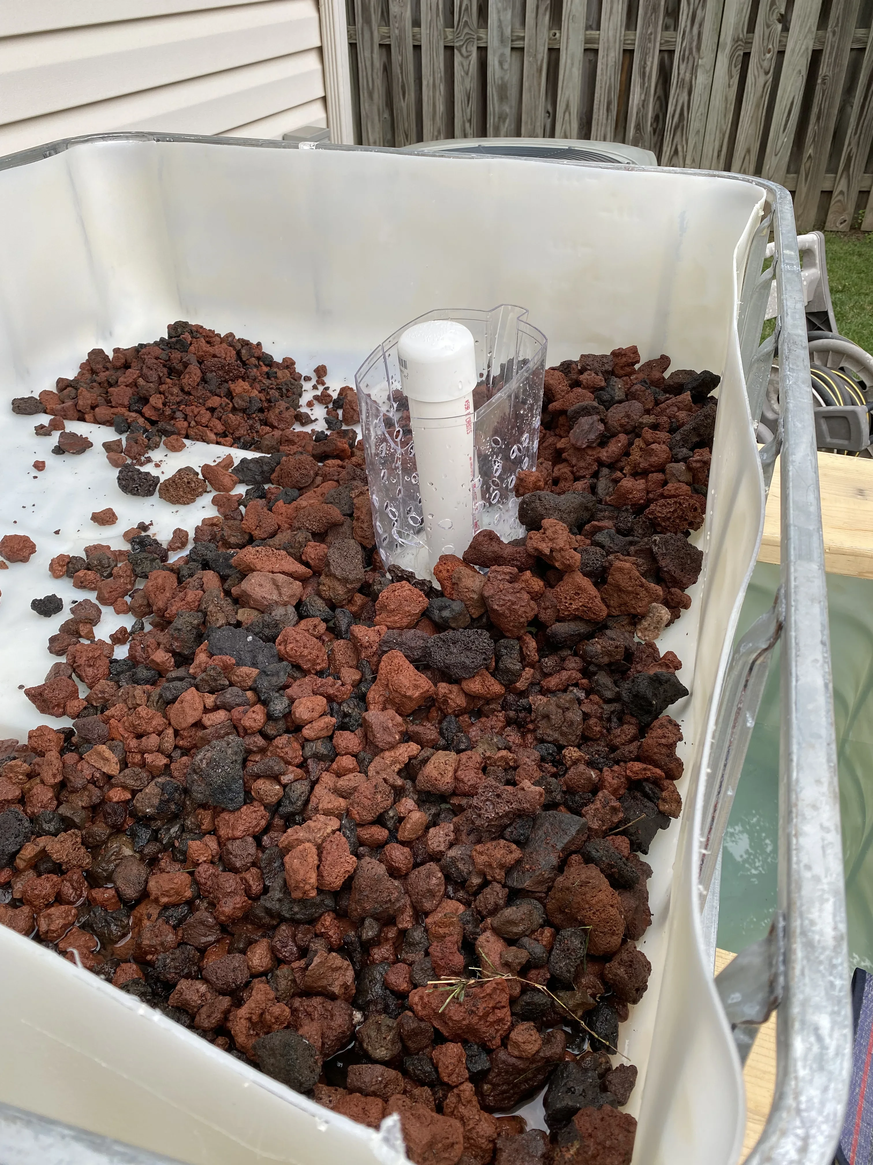 Installing lava rock around the standpipe in an IBC aquaponics grow bed